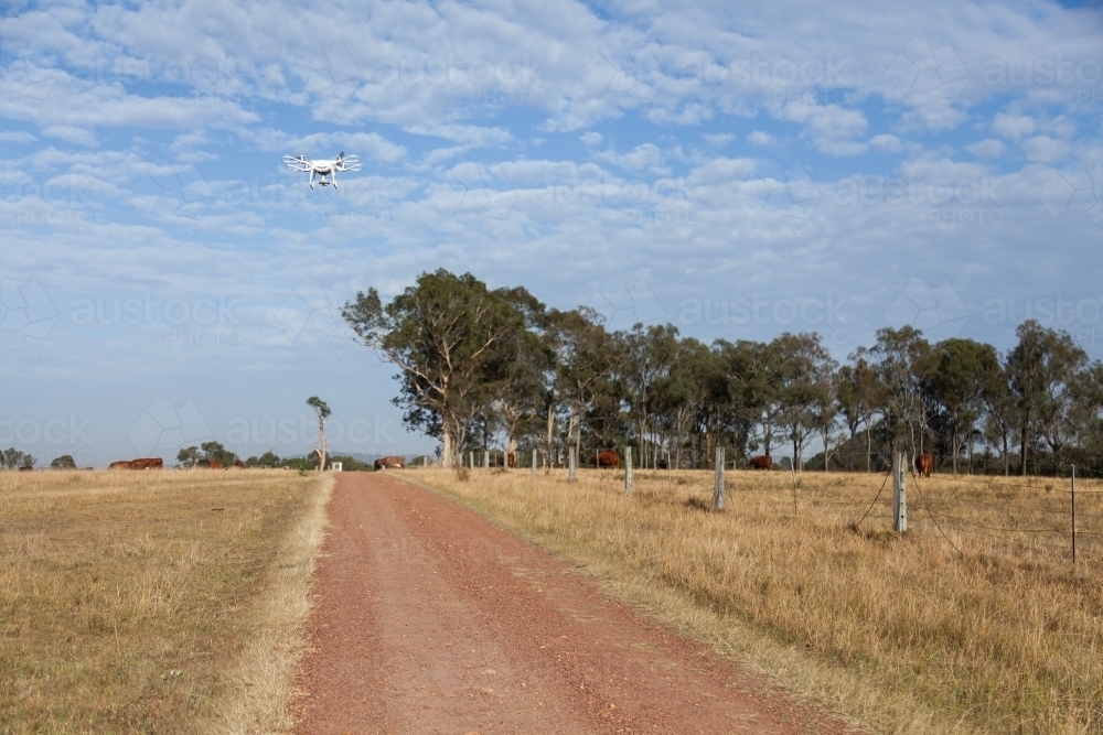 Phantom drone flying above gravel driveway on rural property - Australian Stock Image