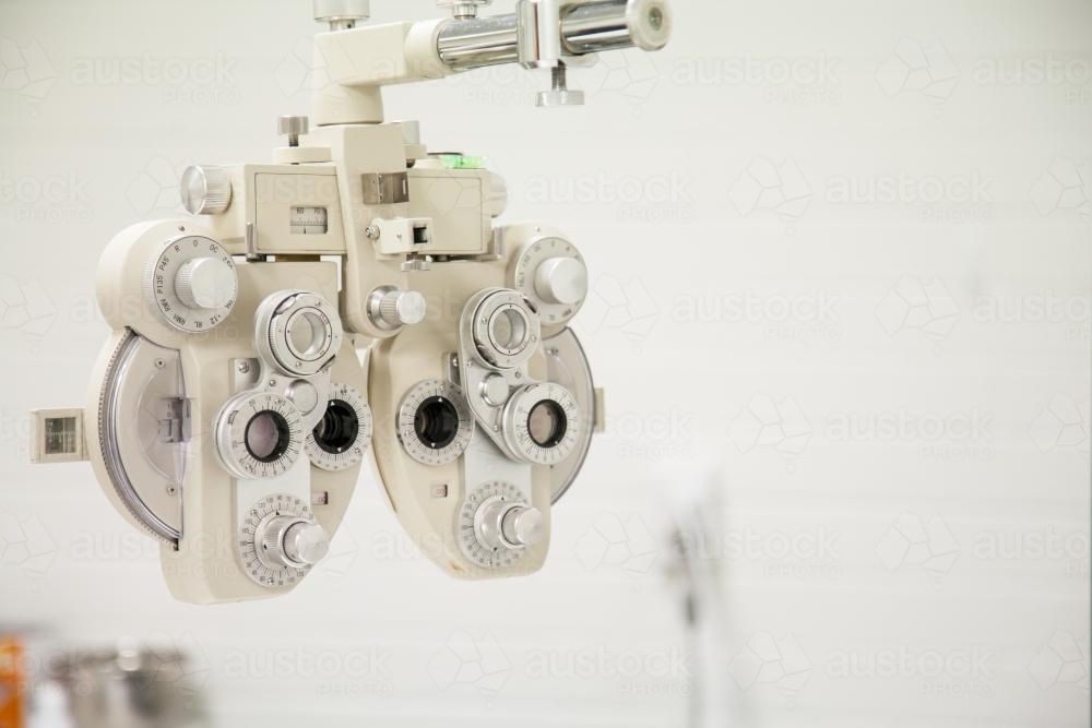 Phoropter, eye doctor machine in a white room - Australian Stock Image