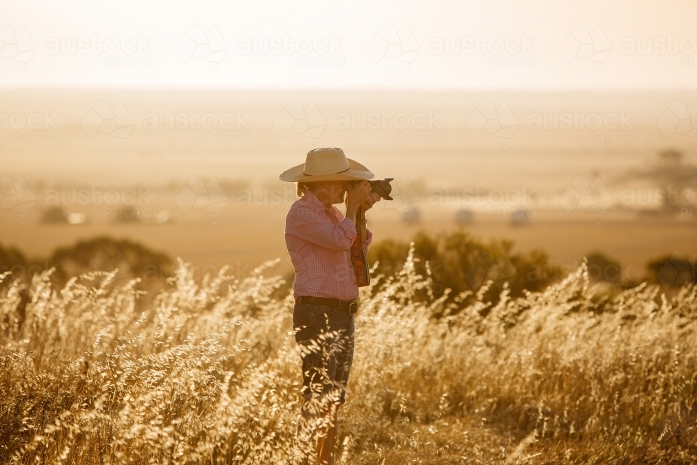 Photographer in the golden light on a farm - Australian Stock Image