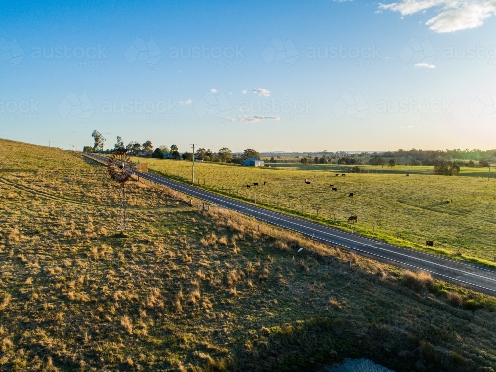 Image of Picturesque country scene at sunset of road through farm ...