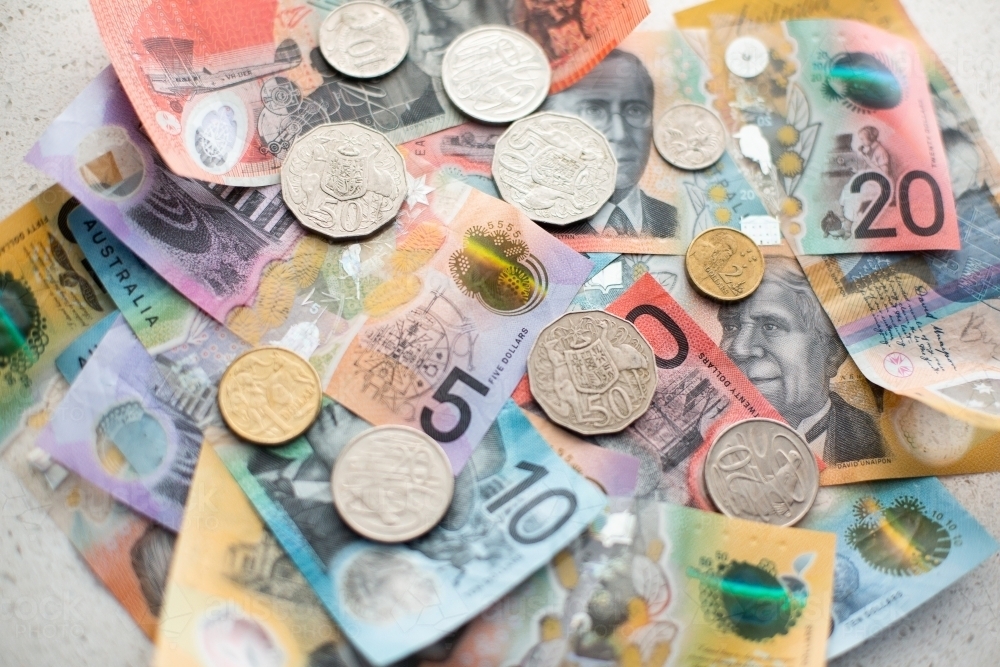 pile of aussie notes and coins on a white benchtop background - Australian Stock Image