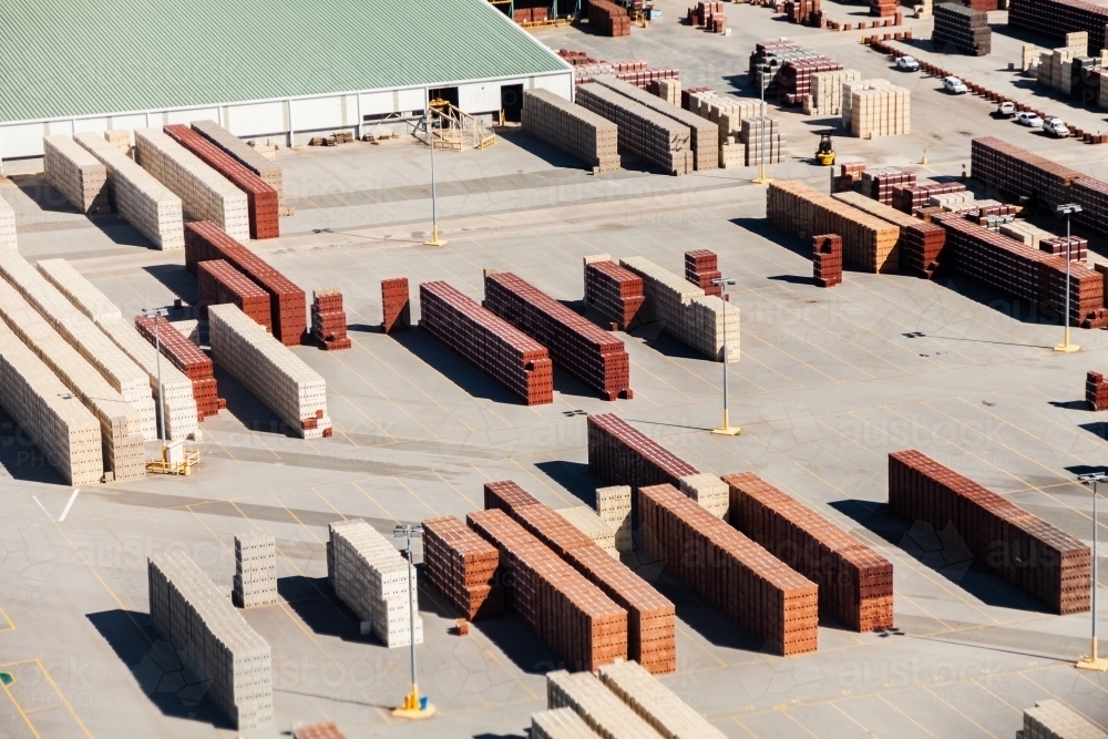 Piles of bricks in store area in industrial area of city - Australian Stock Image