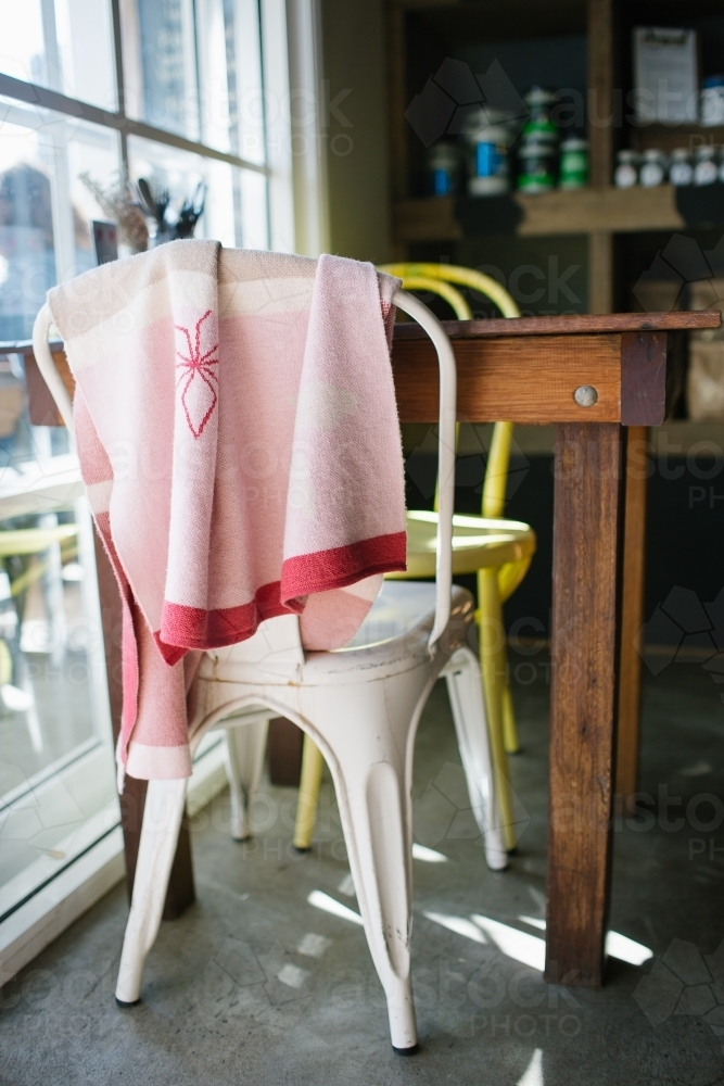 Pink towel hung over chair in restaurant - Australian Stock Image