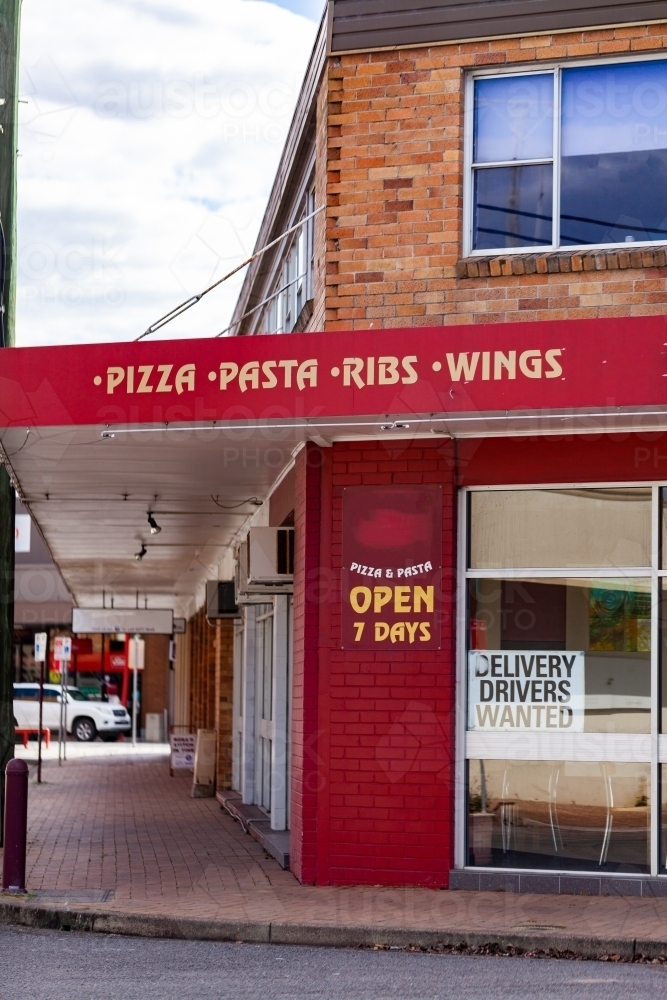 Pizza place sign and shop front on street - Australian Stock Image