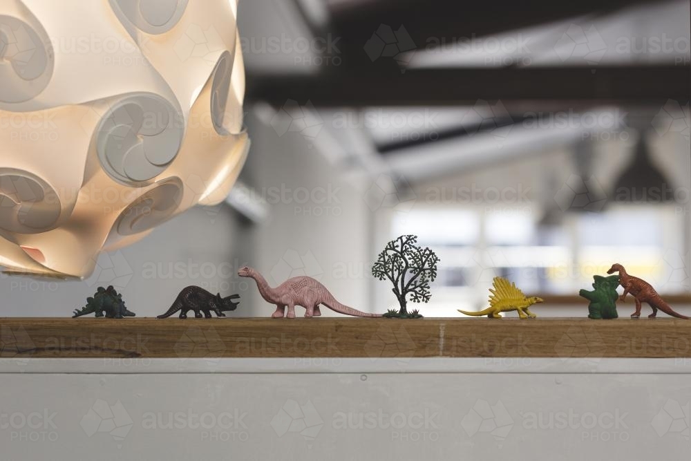 Plastic dinosaurs on ledge in cafe - Australian Stock Image