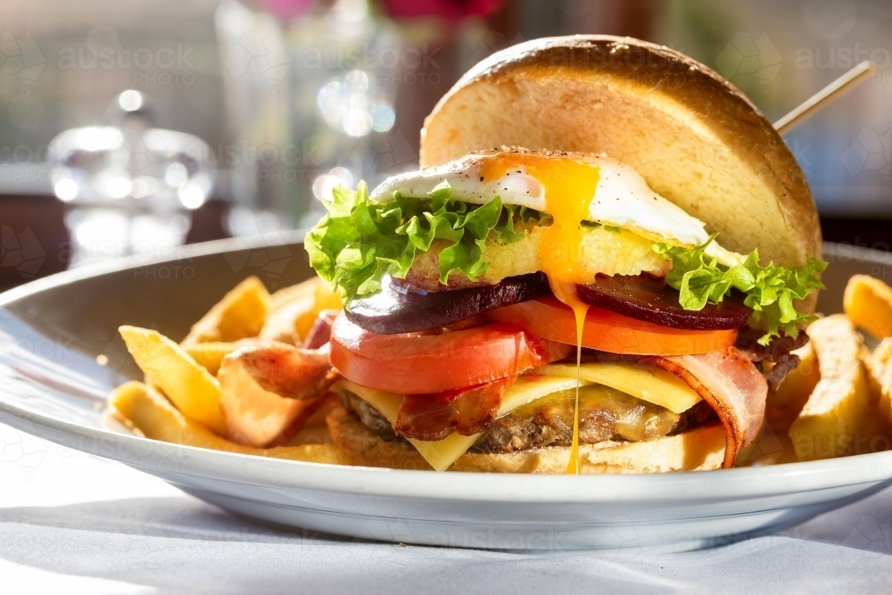 Plate with egg and meat burger with chips - Australian Stock Image