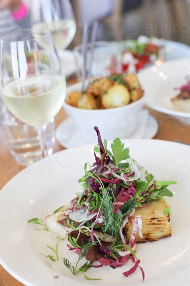 plated dish with grilled vegetables topped with fresh herbs and microgreens - Australian Stock Image