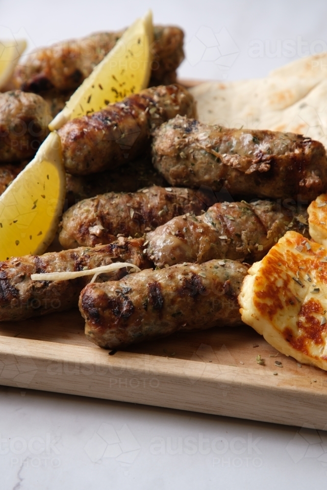 platter of grilled  sausages with herbs on top - Australian Stock Image