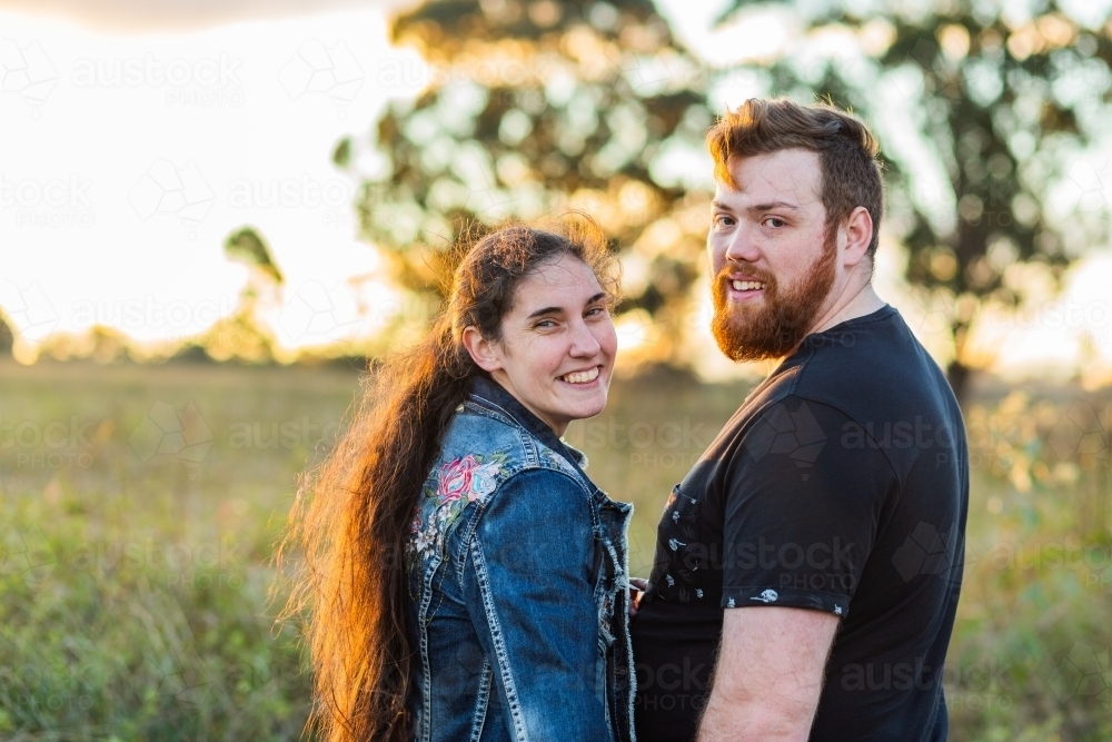 Portrait of a happy australian couple outdoors in sunset light - Australian Stock Image