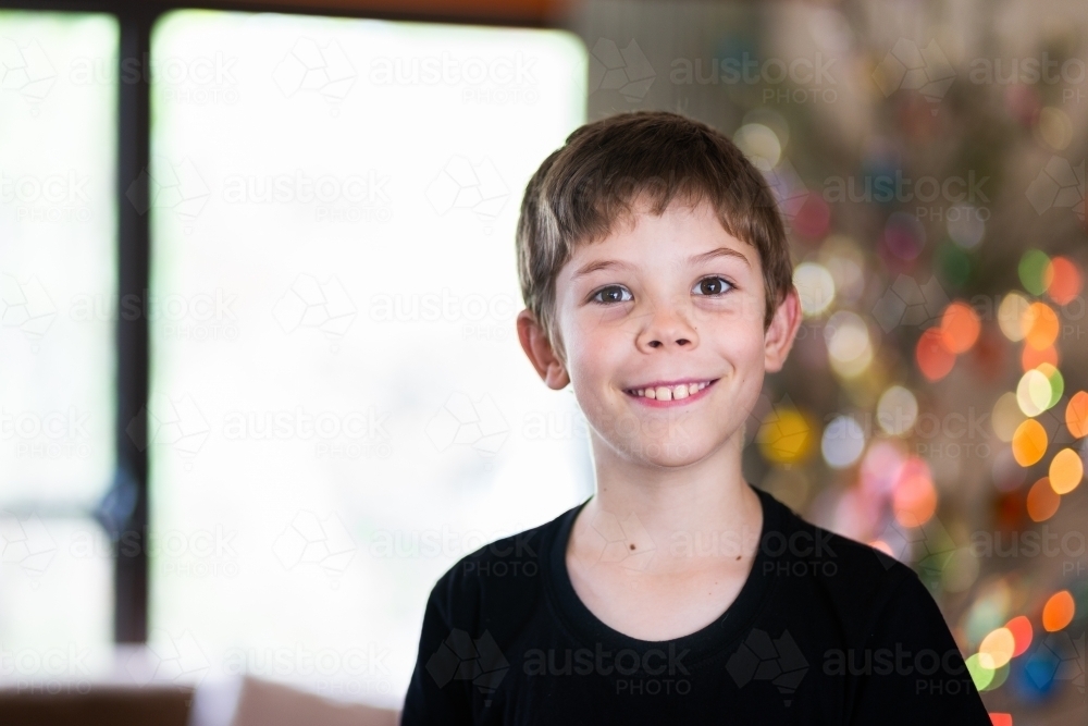 Portrait of a happy kid with brown eyes at Christmas time - Australian Stock Image