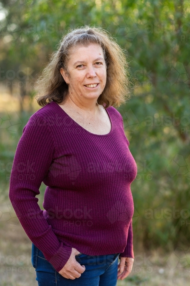 Portrait of a happy middle aged lady standing outside - Australian Stock Image