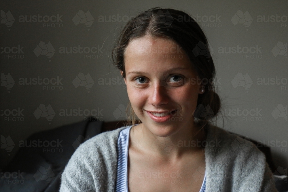 Portrait of a happy young teenage girl indoors - Australian Stock Image