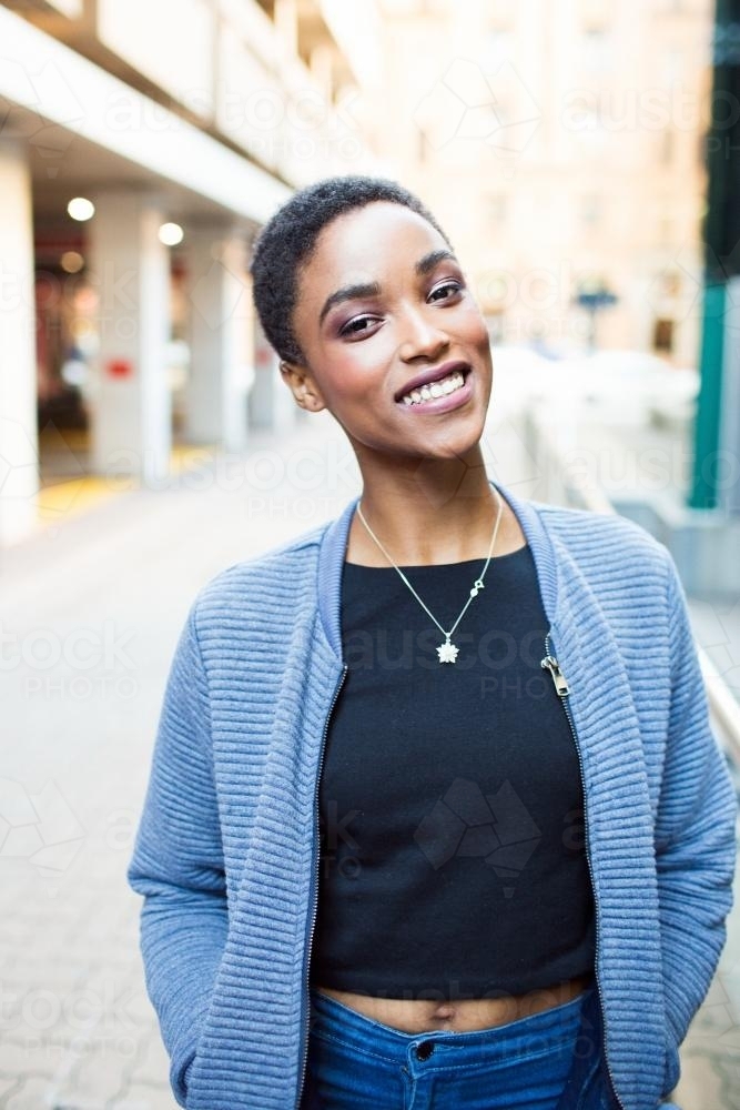 Portrait of a smiling woman walking in the city - Australian Stock Image