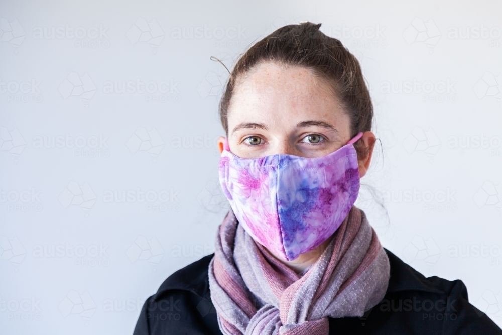portrait of a woman in her twenties wearing a face mask for protection during covid - Australian Stock Image