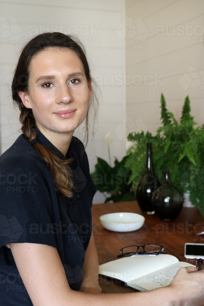 Portrait of a young female creative industry worker sitting at her desk - Australian Stock Image