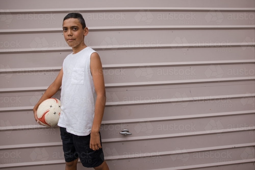 Portrait of a young first nations boy holding a soccer ball - Australian Stock Image