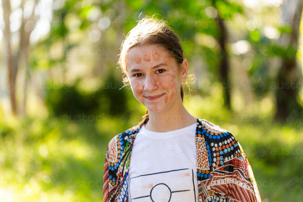 Portrait of aboriginal pre-teen girl with ochre face paint - Australian Stock Image