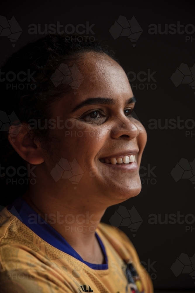 Portrait of Aboriginal woman on dark backdrop - Australian Stock Image