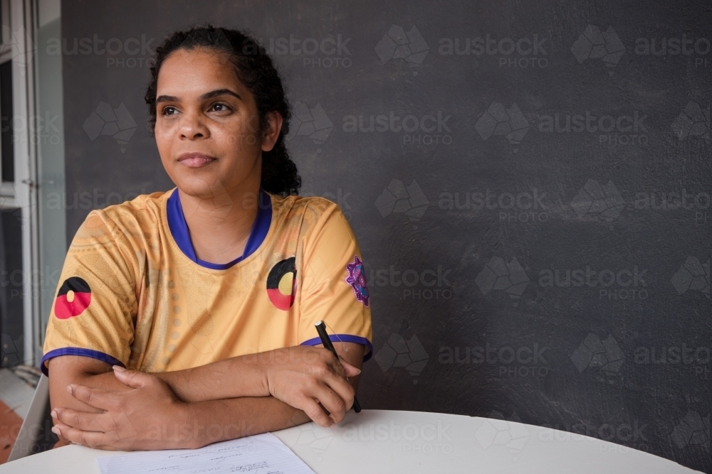 Portrait of Aboriginal woman with pen and paper - Australian Stock Image