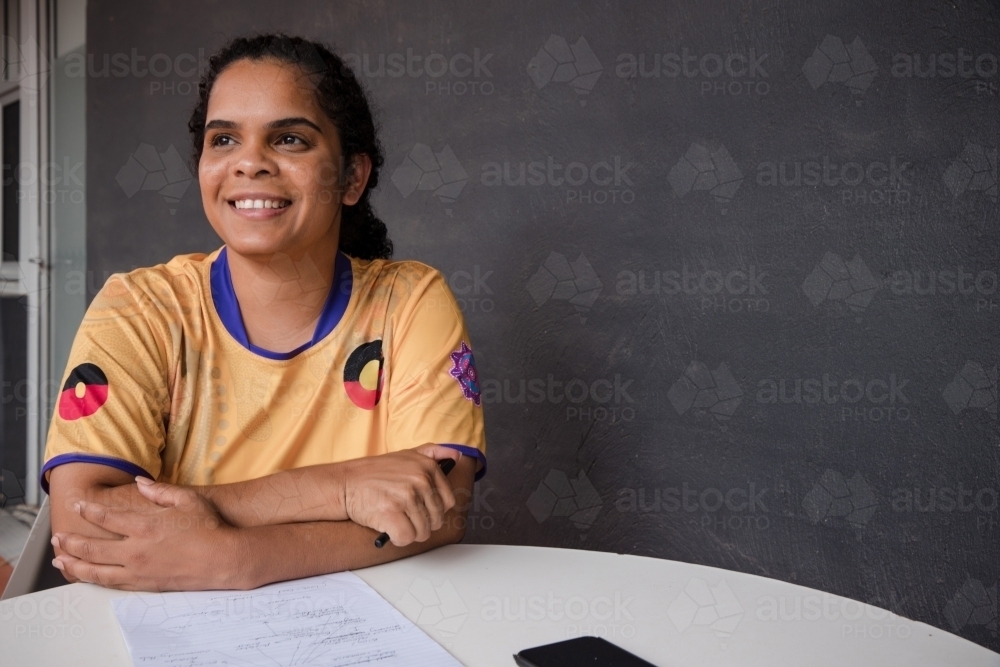 Portrait of Aboriginal woman with pen and paper - Australian Stock Image