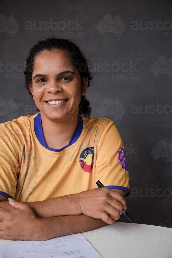 Portrait of Aboriginal woman writing on sheet of paper - Australian Stock Image