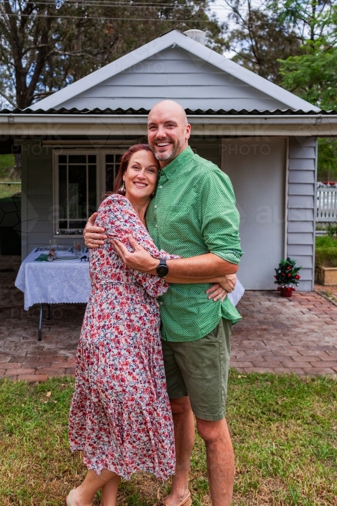 Portrait of Aussie couple in their forties in front of country garage    - Australian Stock Image