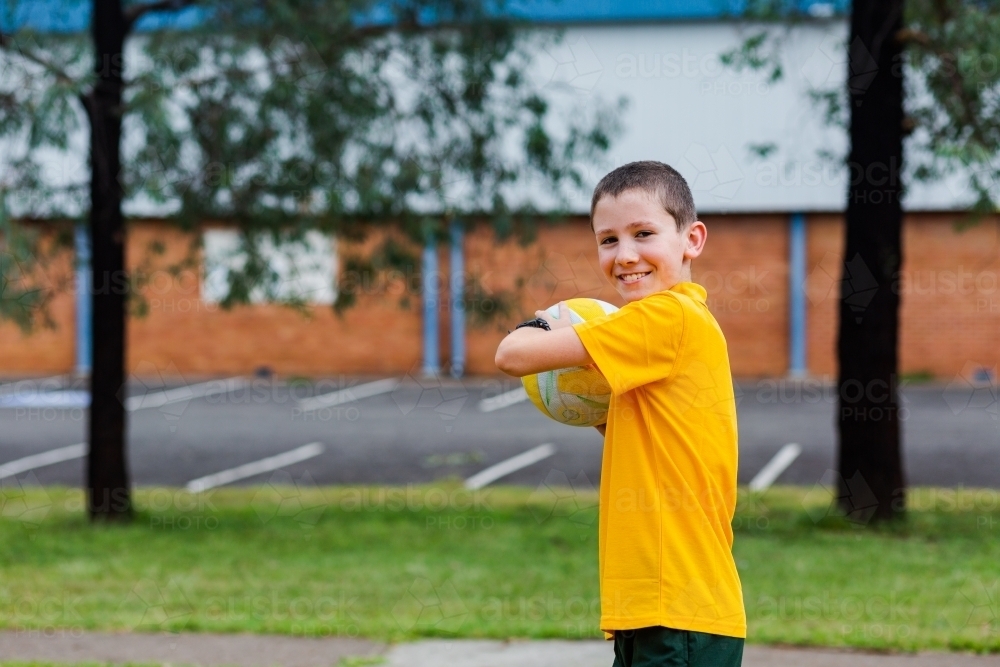 Portrait of Australian primary school child with ball during PE - Australian Stock Image