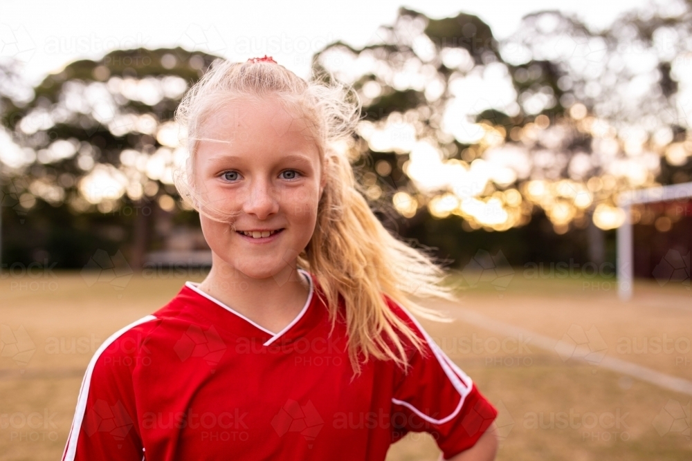 Portrait of happy blonde female soccer player smiling - Australian Stock Image