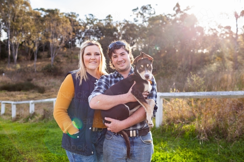 Portrait of happy country couple with pet Australian Kelpie puppy dog - Australian Stock Image