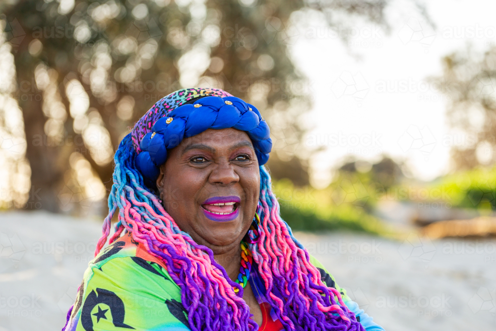 Portrait of happy First Nations Australian Torres Strait Islander woman in her late fifties at beach - Australian Stock Image