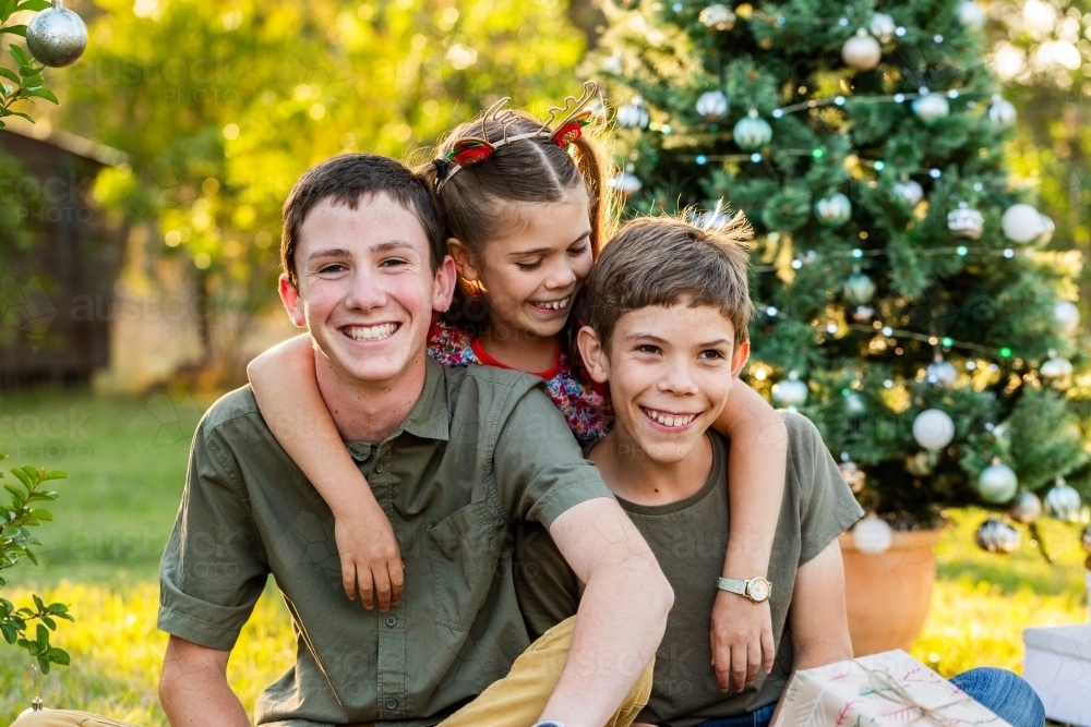 Portrait of happy kids sitting together at Christmastime - Australian Stock Image