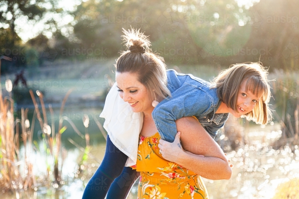 Portrait of happy mother in her thirties with daughter outside - Australian Stock Image