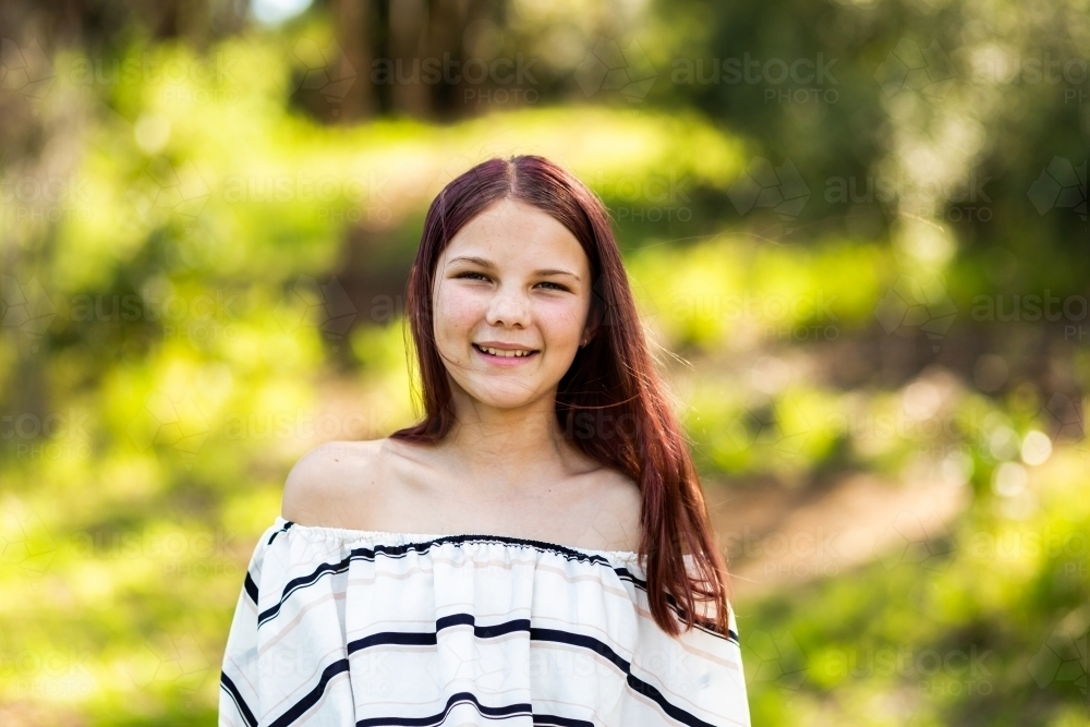 portrait of happy smiling twelve year old girl outside - Australian Stock Image