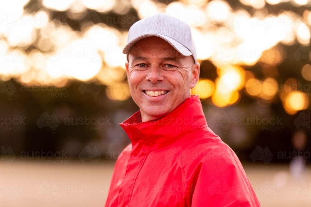 Portrait of male football coach wearing a cap and smiling proudly - Australian Stock Image