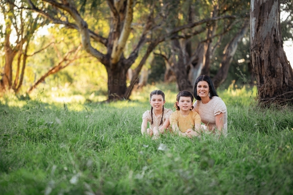 Portrait of mother and children sitting together in Australian bush setting - Australian Stock Image