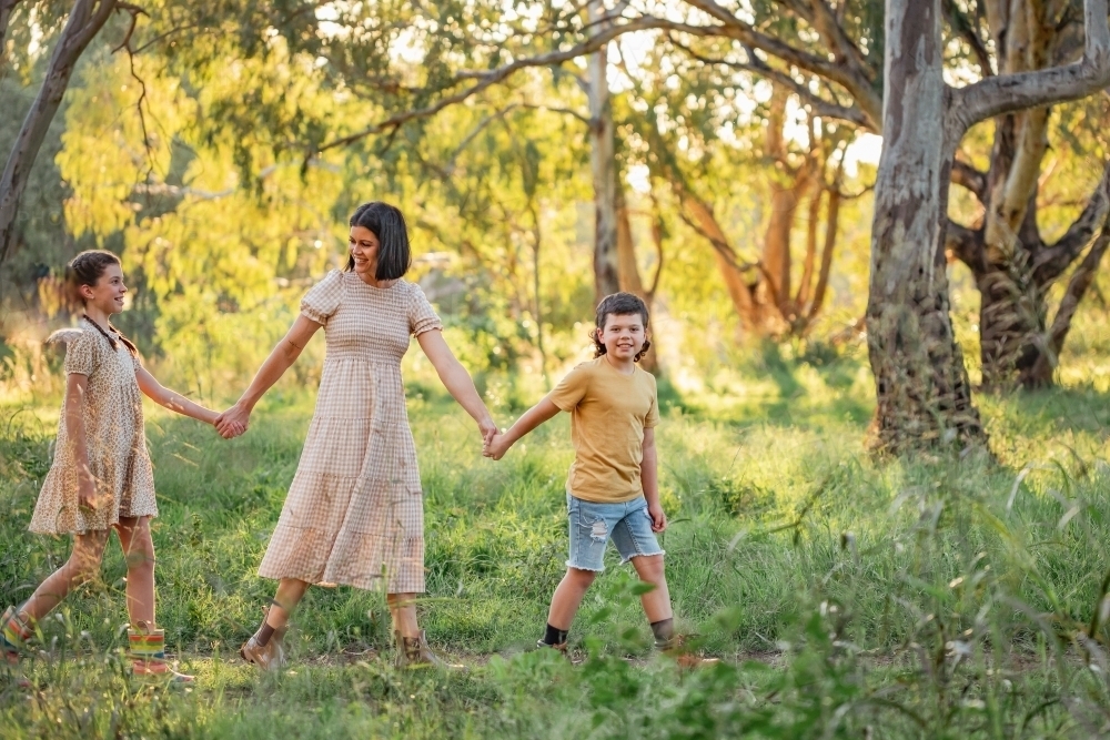Portrait of mother and children walking together in Australian bush setting - Australian Stock Image
