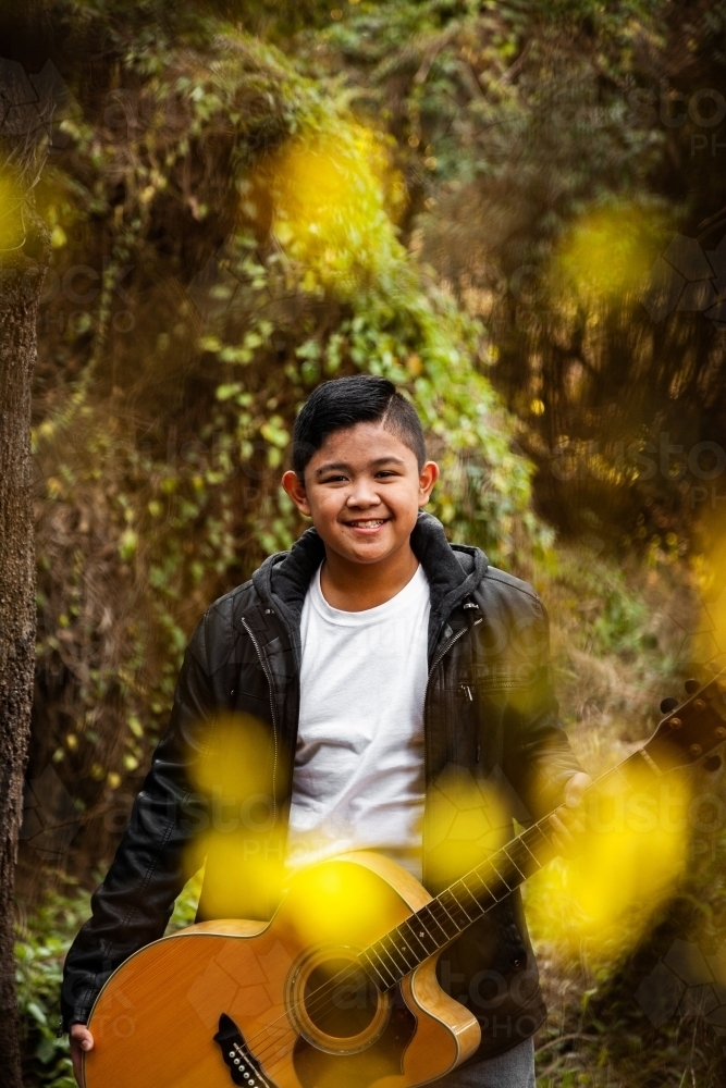 Portrait of musician through trees bokeh foreground - Australian Stock Image