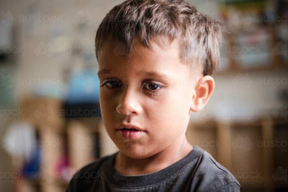 Portrait of young Aboriginal boy looking sad - Australian Stock Image