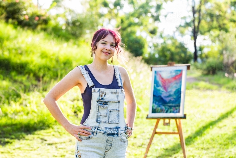 Portrait of young artist with hands on hips backlit by sunlight - Australian Stock Image