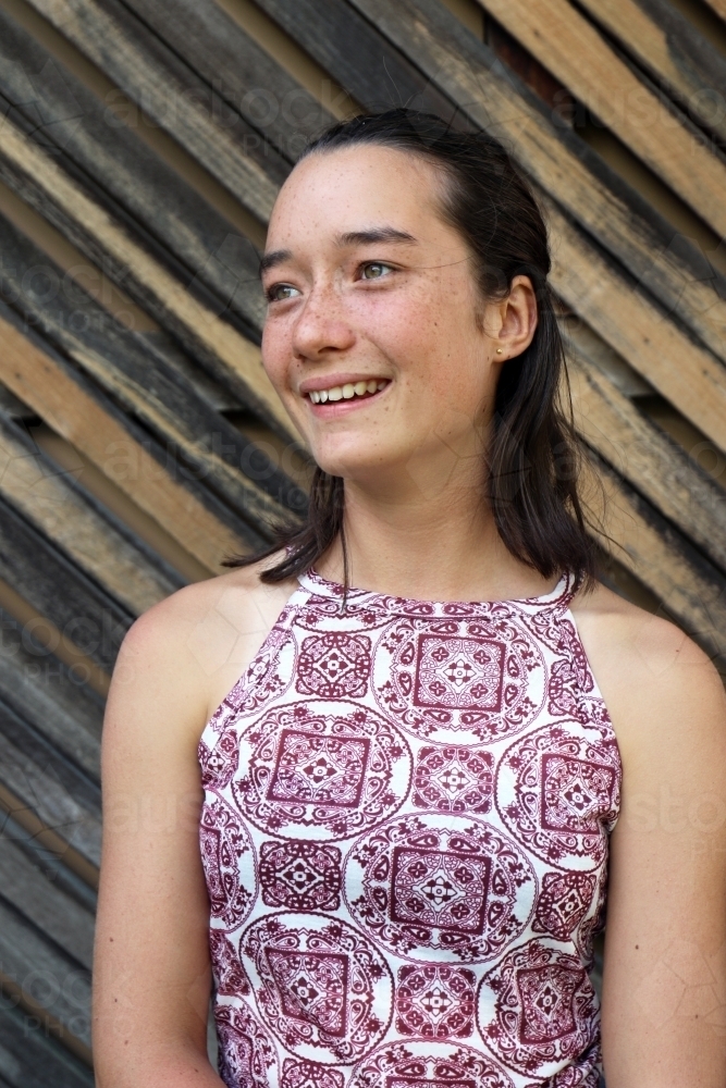 Portrait of young female outdoors with textured wooden background - Australian Stock Image