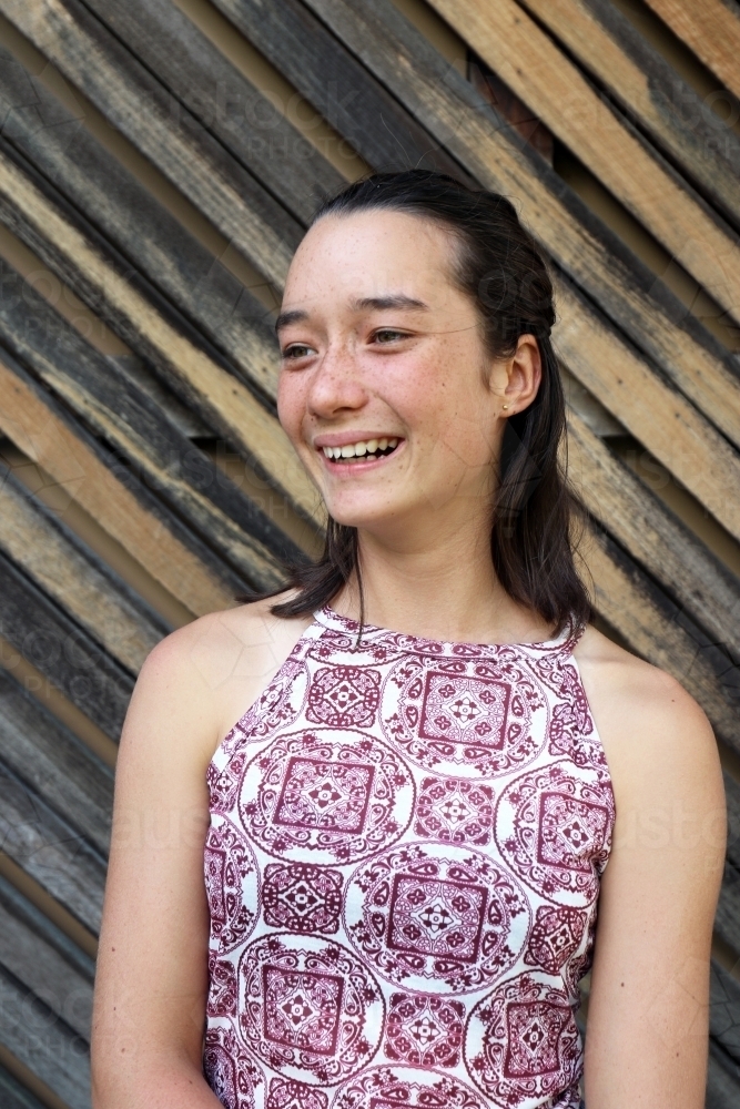 Portrait of young female outdoors with textured wooden background - Australian Stock Image