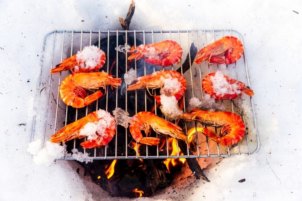 Prawns being cooked over pit in the snow - Australian Stock Image