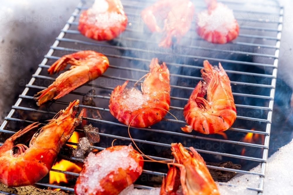 Prawns being cooked over pit in the snow - Australian Stock Image