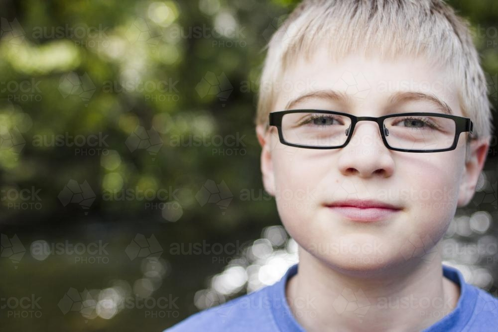 Pre-teen boy with blonde hair wearing glasses - Australian Stock Image