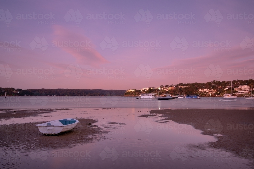 Predawn on tidal flats with stranded boat - Australian Stock Image