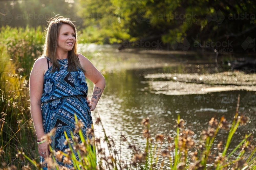 pregnant woman standing beside river - Australian Stock Image