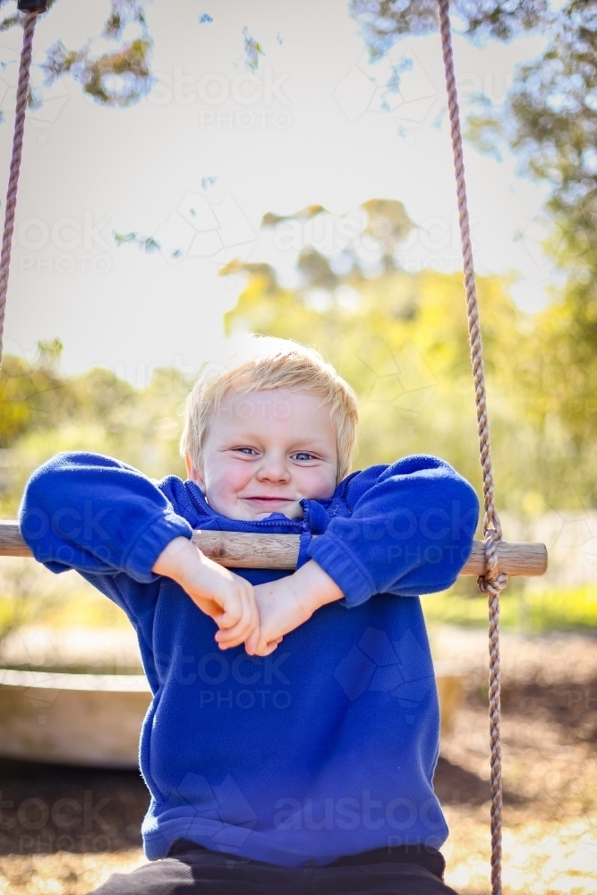 Preschool age child posing on rope ladder swing for kindergarten photos. Portrait of young boy. - Australian Stock Image