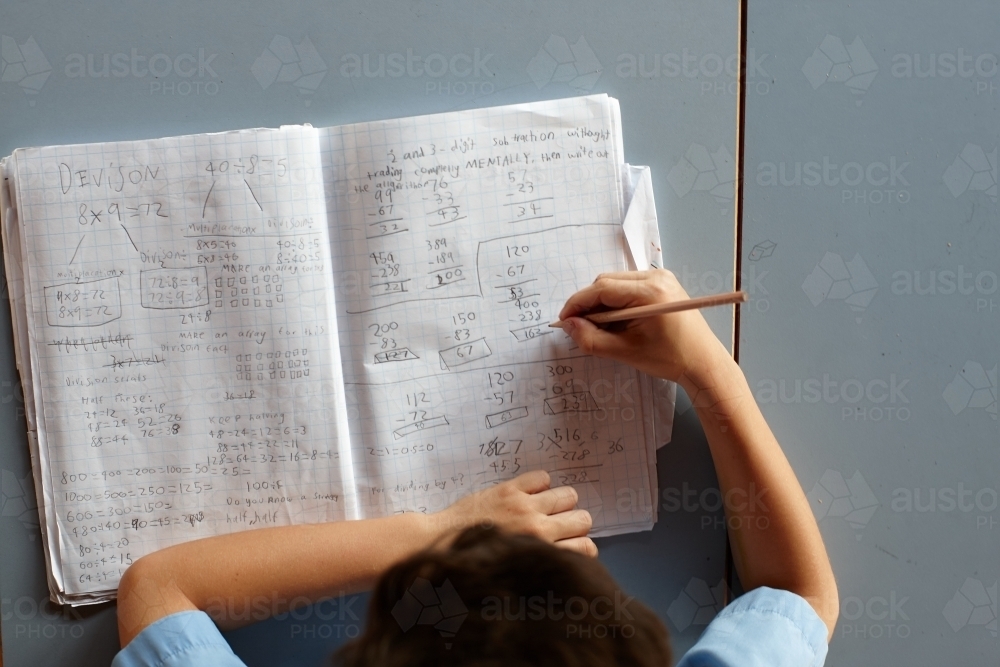 Primary school student in classroom working on homework - Australian Stock Image