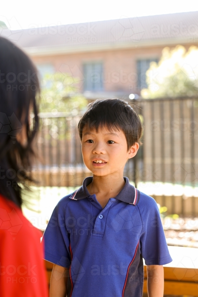 primary school students talking together - Australian Stock Image