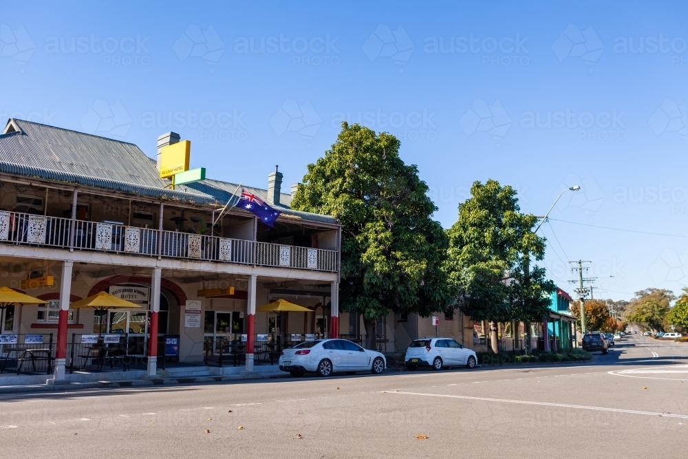 Pub in county town of Muswellbrook flying australian flag with cars parked outside - Australian Stock Image